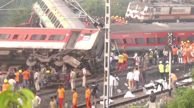 Petugas penyelamat dan petugas polisi bekerja di samping gerbong kereta yang hancur, menyusul tabrakan maut dua kereta, di Balasore, India 3 Juni 2023. Foto: ANI/Reuters TV melalui REUTERS