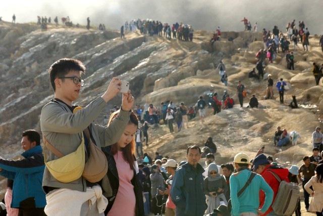 Pengunjung melihat kawah dari kaldera Gunung Ijen di Banyuwangi, Jawa Timur, Minggu (4/5/2023).  Foto: Budi Candra Setya/ANTARA FOTO