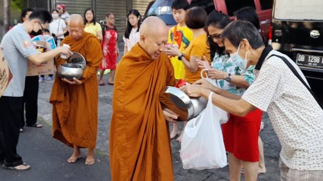 Umat Buddha di Manado memberikan sedekah untuk para biksu pada tradisi Pindapata jelang Hari Trisuci Waisak 2567 BE/2023. (foto: dokumentasi Vihara Dhammadipa Manado)