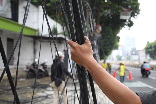 Petugas Dinas Bina Marga DKI Jakarta menertibkan kabel jaringan utilitas di kawasan Mampang, Jakarta Selatan, Senin (5/6/2023). Foto: Fitra Andrianto/kumparan