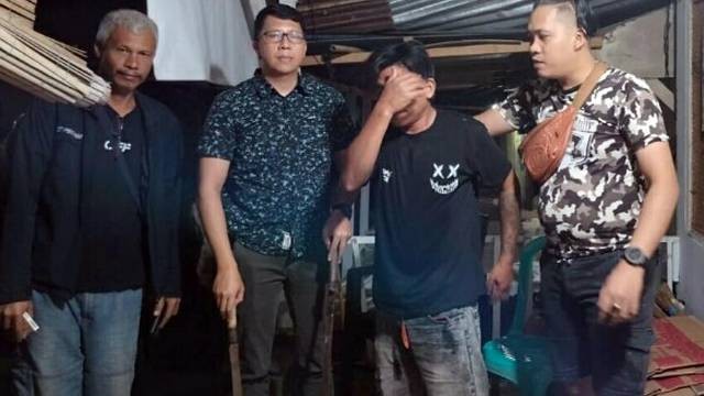 Pelaku aniaya seorang pedagang tahu di Kota Bitung saat ditangkap oleh polisi tampak menutupi wajahnya. (foto: dokumen istimewa)