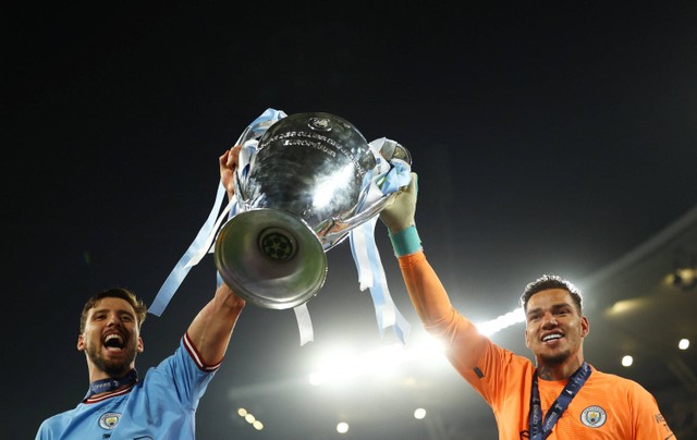 Ruben Dias dan Ederson dari Manchester City merayakan dengan trofi setelah memenangkan Liga Champions di Stadion Olimpiade Ataturk, Istanbul, Turki. Foto: Molly Darlington/Reuters