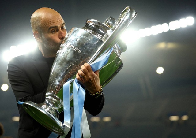 Manajer Manchester City Pep Guardiola mencium trofi setelah memenangkan Liga Champions di Stadion Olimpiade Ataturk, Istanbul, Turki. Foto: Molly Darlington/Reuters