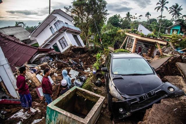 Warga menyelamatkan barang-barang dari rumah yang rusak akibat gempa di Cianjur, Jawa Barat, Selasa (22/11/2022). Foto: Aditya Aji/AFP