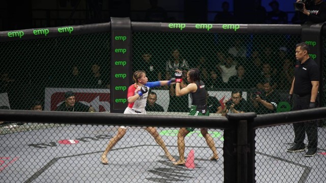 Pertarungan antara atlet MMA perempuan antara Anggie Mandagi (kiri) dan Dwi Retno (kanan) dalam One Pride 69 Jogja Istimewa, Sabtu (10/6). Foto: Widi RH Pradana