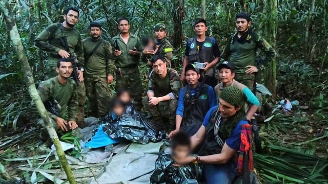 Sejumlah tentara berpose dalam sebuah foto bersama dengan anak-anak, yang wajahnya diburamkan.