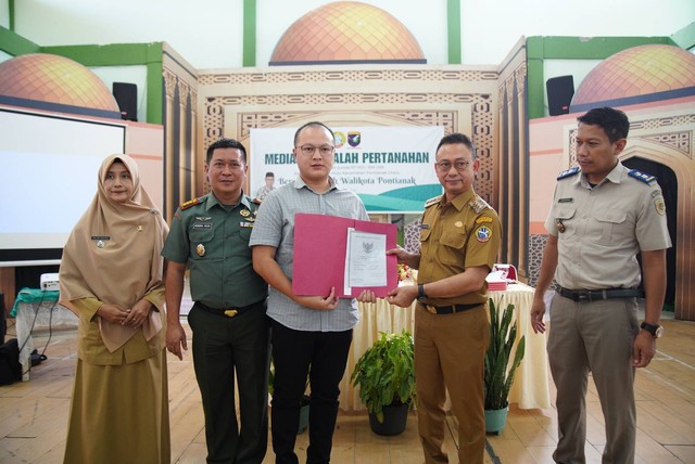 Pihak perusahaan pemegang HGB, Bernard, menyerahkan sertifikat secara simbolis kepada Wali Kota Pontianak Edi Rusdi Kamtono untuk selanjutnya diproses oleh BPN Kota Pontianak. Foto: Prokopim Pemkot Pontianak