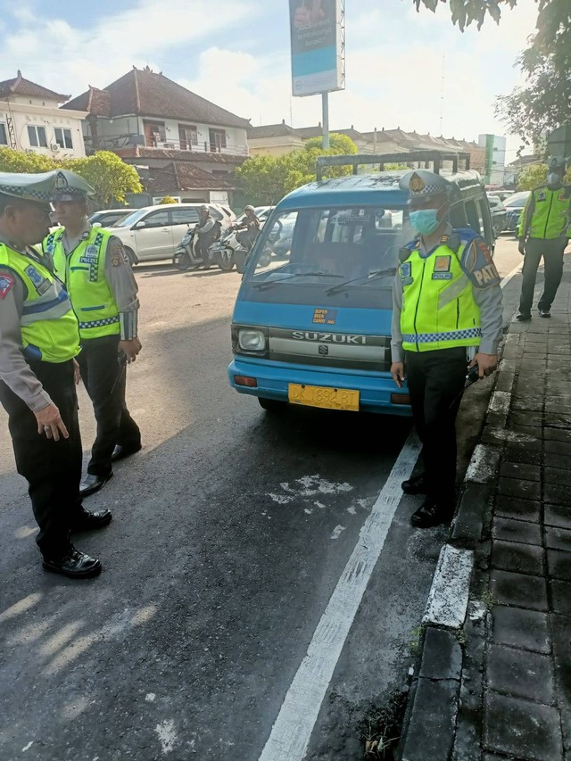 Polisi tilang WN Amerika Serikat yang kendarai angkot di Bali.  Foto: Polresta Denpasar
