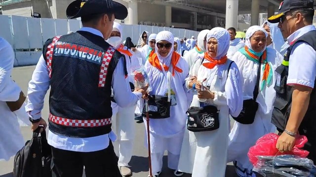 Petugas membagikan roti dan sandal untuk jemaah Haji di Masjidil Haram. Foto: MCH 2023