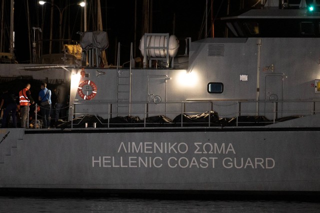 Petugas membawa jenazah korban kecelakaan kapal yang membawa migran di pelabuhan kota Kalamata, Yunani, Rabu (14/6/2023). Foto: Angelos Tzortzinis / AFP