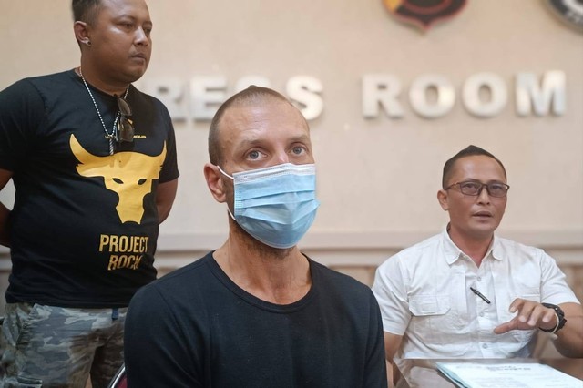 WN Amerika Serikat Ithomas Charles Flach JR (pakai masker) yang mengadang dan merusak mobil dinas polisi di Polda Bali. Foto: Denita BR Matondang/kumparan