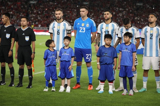 Jan Ethes Srinarendra (kedua kiri) menjadi player escort atau maskot anak saat pertandingan Timnas Indonesia melawan Timnas Argentina pada pertandingan FIFA Matchday di Stadion Utama Gelora Bung Karno, Jakarta, Senin (19/6/2023). Foto: Aditia Noviansyah/kumparan