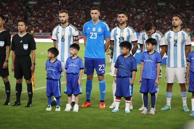 Jan Ethes Srinarendra (kedua kiri) menjadi player escort atau maskot anak saat pertandingan Timnas Indonesia melawan Timnas Argentina pada pertandingan FIFA Matchday di Stadion Utama Gelora Bung Karno, Jakarta, Senin (19/6/2023). Foto: Aditia Noviansyah/kumparan