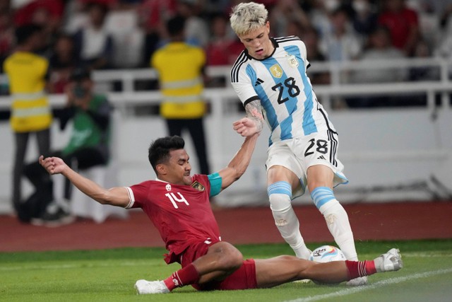 Alejandro Garnacho Ferreyra dari Argentina berebut bola dengan pemain Indonesia Asnawi Mangkualam dalam pertandingan sepak bola persahabatan mereka di Stadion Utama Gelora Bung Karno di Jakarta, Indonesia, Senin, (19/6/2023). Foto: Tatan Syuflana/AP Photo