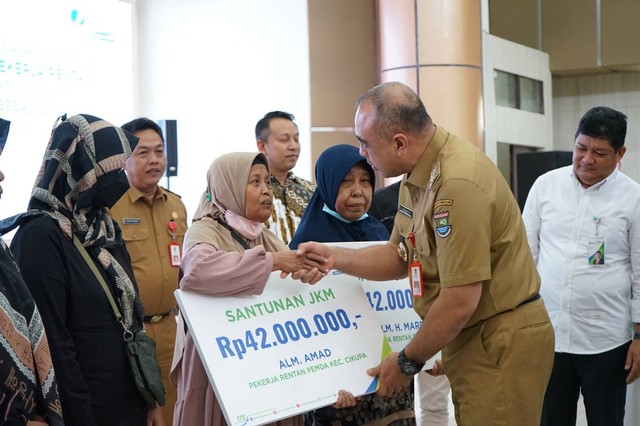 Bupati Tangerang Ahmed Zaki Ismail saat memberikan santunan kepada ahli waris yang terlindung dalam BPJS Ketenagakerjaan. Foto: BPJS Ketenagakerjaan