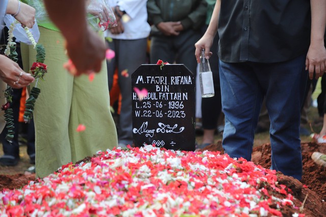 Keluarga jenazah Fajri menaburkan bunga ke makam usai pemakaman di TPU Menteng Pulo, Jakarta, Kamis (22/6/2023). Foto: Jamal Ramadan/kumparan