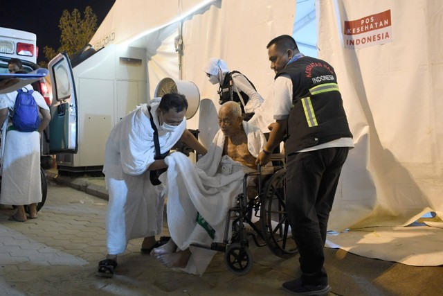 Petugas kesehatan membantu calon haji yang telah sembuh usai perawatan di tenda pos kesehatan jelang pelaksanaan wukuf di Arafah, Arab Saudi, Selasa (27/6/2023). Foto: Wahyu Putro A/Antara Foto