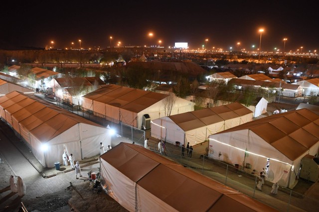 Jamaah calon haji melintas di depan tenda jelang pelaksanaan wukuf di Arafah, Arab Saudi, Selasa (27/6/2023). Foto: Wahyu Putro A/Antara Foto