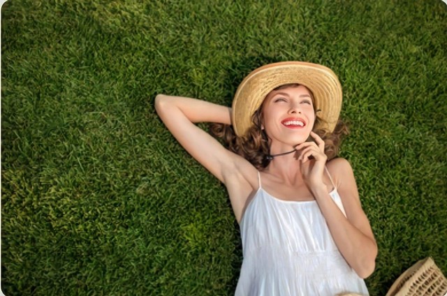 Ilustrasi happy young woman lying on green. Sumber: Shutterstock