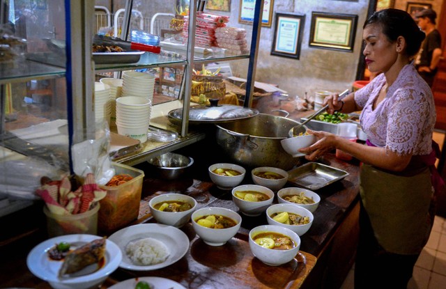 Karyawan meyiapkan sajian kuliner ikan laut yang akan disajikan untuk pembeli di Warung Mak Beng, Sanur, Denpasar, Bali, Kamis (29/6/2023). Foto: ANTARA FOTO/Fikri Yusuf