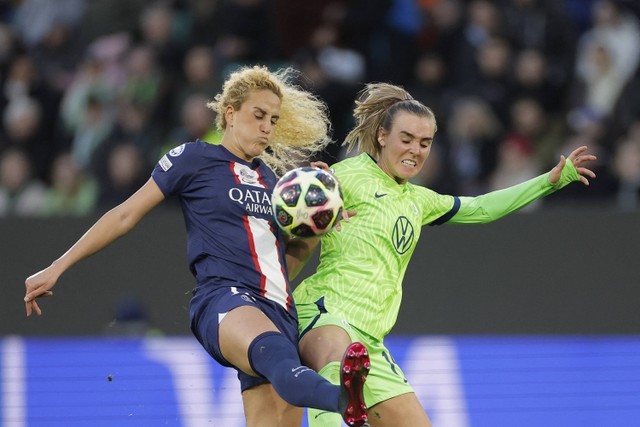 Gelandang Prancis Paris Saint-Germain Kheira Hamraoui (Kiri) dan gelandang Wolfsburg asal Belanda Juill Roord bersaing memperebutkan bola selama pertandingan leg kedua perempat final Liga Champions Wanita UEFA di Wolfsburg, Jerman, pada 30/3/2023. Foto: Aneh Andrsen / AFP