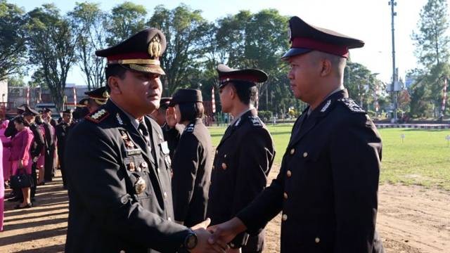 Kapolresta Manado, Kombes Pol Juliantor Sirait memberikan selamat kepada para personel yang mendapatkan kenaikan pangkat, selepas upacara peringatan HUT Bhayangkara ke-77.