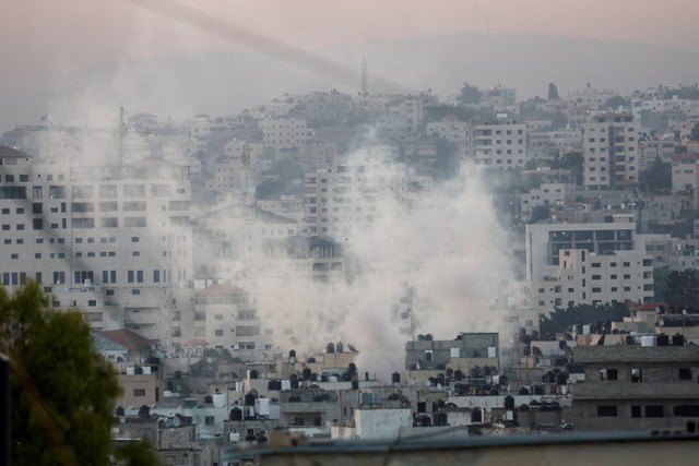 Asap mengepul selama operasi militer Israel di Jenin, di Tepi Barat yang diduduki Israel pada Senin (3/7/2023). Foto: Mohamad Torokman/Reuters