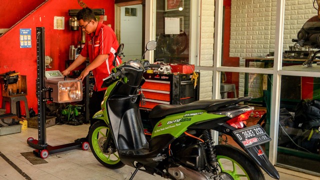 Mekanik melepas baterai motor bbm yang dikonversi ke motor listrik di bengkel Bacip Moto Shop di Bandung, Jawa Barat, Senin (3/7/2023).  Foto: Raisan Al Farisi/ANTARA FOTO