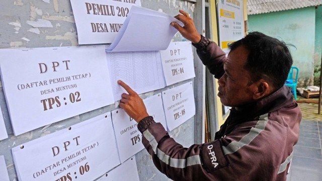 Warga mencari namanya pada papan pengumuman daftar pemilih tetap (DPT) Pemilu 2024 di Balai Desa Muntung, Candiroto, Temanggung, Jawa Tengah, Selasa (4/7/2023). Foto: ANTARA FOTO/Anis Efizudin