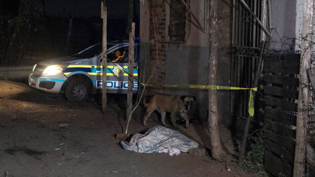 Mayat yang ditutupi selimut sekitar 300 meter dari tempat kejadian kebocoran gas di pemukiman informal Angelo di Boksburg pada Kamis (6/7/2023). Foto: Wikus de Wet / AFP