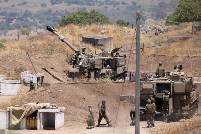 Tentara Israel berdiri di dekat kendaraan artileri self-propelled tentara di pinggiran Kiryat Shmona dekat perbatasan Israel dengan Lebanon, Kamis (6/7/2023). Foto: Jalaa Marey/AFP