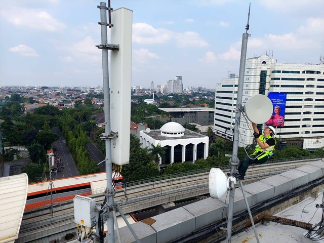 Teknisi melakukan pemeliharaan perangkat Base Transceiver Station (BTS) milik XL Axiata di sekitar Jalan HR. Rasuna Said, Jakarta Selatan, tidak jauh dari jalur LRT. Foto: XL Axiata