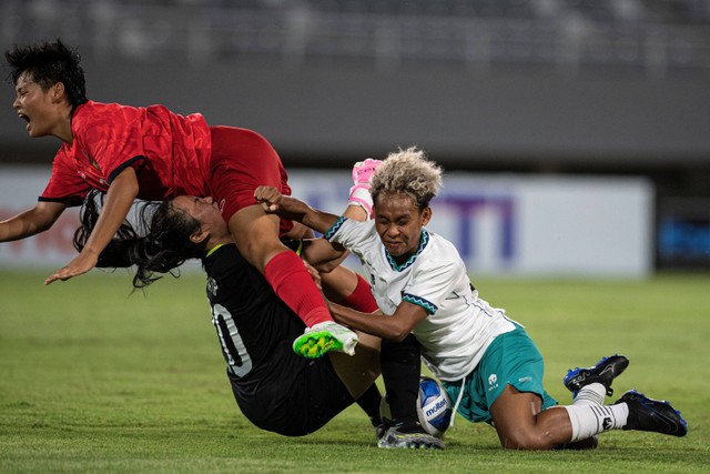 Pesepak bola Timnas Wanita Indonesia U-19 Marsela Yuliana Awi (kanan) berebut bola dengan pesepak bola Timnas Laos Ntza Sumalu (atas) dan Tatip Keo Inkhouan (tengah) pada pertandingan penyisihan grup A AFF U-19 Women Championship 2023. Foto: Nova Wahyudi/Antara Foto