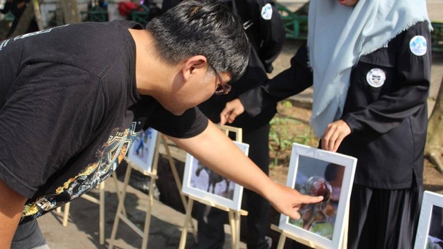 Seorang warga yang tengah melihat koleksi foto dalam kegiatan pameran fotografi mahasiswa di Palembang, Minggu (9/7) Foto: ary priyanto/urban id