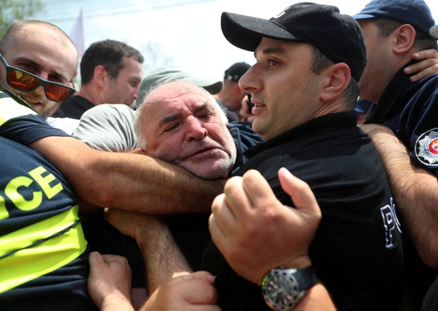 Pengunjuk rasa anti-LGBT berkelahi dengan polisi ketika mereka mencoba masuk ke lokasi Tbilisi Pride Fest, di Tbilisi, Georgia, Sabtu (8/7/2023). Foto: Irakli Gedenidze/Reuters