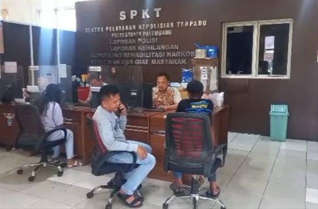 Pria bernama Umar (baju hitam) saat membuat laporan di SPKT Polrestabes Palembang. (ist)