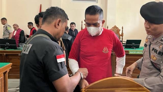 Petugas melepaskan borgol AKBP Achiruddin Hasibuan sebelum mengikuti sidang di Pengadilan Negeri Medan pada Rabu (12/7/2023). Foto: Tri Vosa/kumparan