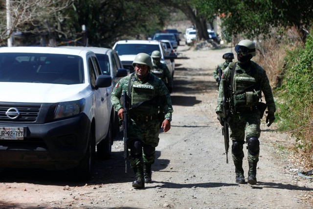 Petugas gabungan polisi dan tentara Meksiko melakukan penjagaan ketat di lokasi pengeboman yang menewaskan enam polisi Meksiko di wilayah kartel Generasi Baru Jalisco. Foto: Fernando Carranza/REUTERS