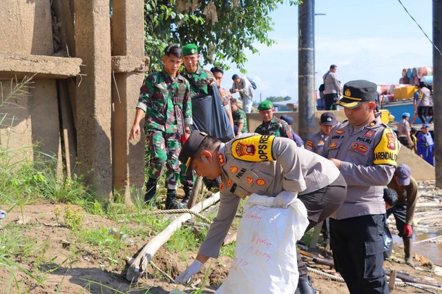 Kapolres Sintang, AKBP Dwi Prasetyo Wibowo, ikut memungut sampah saat kerja bakti di kawasan waterfront. Foto: Dok. Polres Sintang