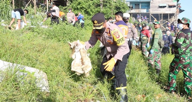 Kapolres Sekadau membersihkan sampah di bantaran Sungai Kapuas. Foto: Dok. Polres Sekadau