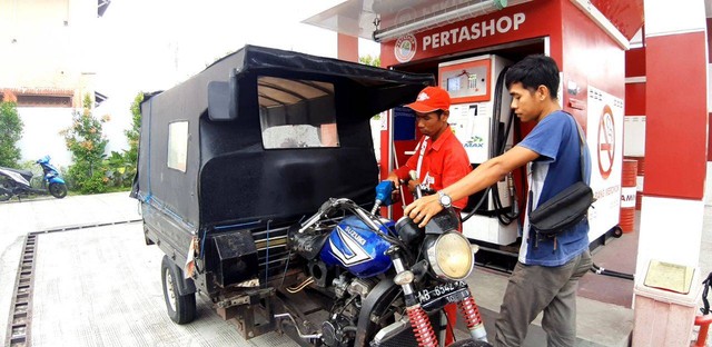 Petugas Pertashop sedang mengisi bensin ke sebuah kendaraan bermotor. Foto: Len/Tugu Jogja