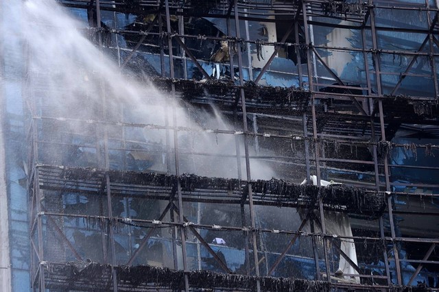 Petugas pemadam kebakaran dalam proses pendinginan di gedung K-Link Gatot Subroto, Jakarta, usai kebakaran, Sabtu (15/7/2023). Foto: Jamal Ramadhan/kumparan