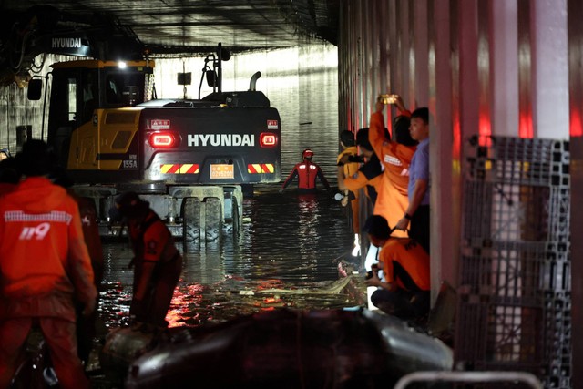 KoPetugas penyelamat ikut dalam operasi pencarian dan penyelamatan di dalam underpass yang terendam banjir akibat hujan deras di Cheongju, Korea Selatan, Minggu (16/7/2034). Foto: Yonhap/via REUTERS 