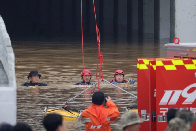 Petugas penyelamat mengambil bagian dalam operasi pencarian dan penyelamatan di dekat underpass yang terendam banjir akibat hujan deras di Cheongju, Korea Selatan, Minggu (16/7/2034). Foto: Kim Hong-Ji/REUTERS