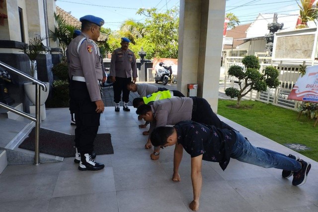 Empat polisi saat dihukum push-up. Foto: Dok. Polda Bali