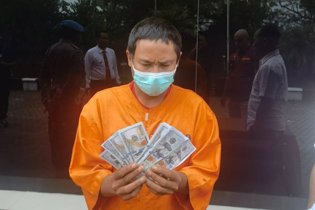 Polisi menunjukkan barang bukti dan tersangka Sang Nyoman Trimayasa yang beli dolar AS palsu setara Rp 1,5 Miliar di Jakarta. Foto: Polsek Kintamani