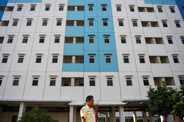 Seorang sekuriti berkomunikasi dengan radio panggilnya di salah satu tower rumah susun sederhana sewa (Rusunawa) Nagrak, Cilincing, Jakarta Utara, Selasa (18/7/2023). Foto: M Risyal Hidayat/Antara Foto 