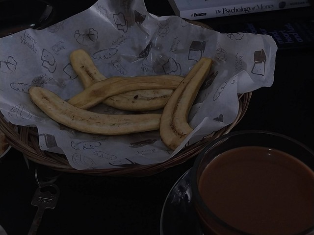 Pisang goroho goreng belah dua dan segelas kopi susu. Dokumentasi Pribadi
