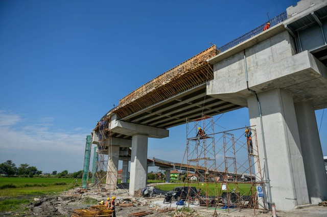 Pekerja menyelesaikan proyek pembangunan jembatan menuju Stasiun Kereta Cepat Jakarta Bandung di Tegalluar, Kabupaten Bandung, Jawa Barat, Jumat (21/7/2023).  Foto: Raisan Al Farisi/ANTARA FOTO