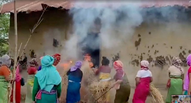 Para wanita membakar jerami di rumah terdakwa dalam kasus video viral Manipur, di Pechi Awang Leikai, Manipur, India, Kamis (20/7/2023). Foto: ANI/melalui REUTERS